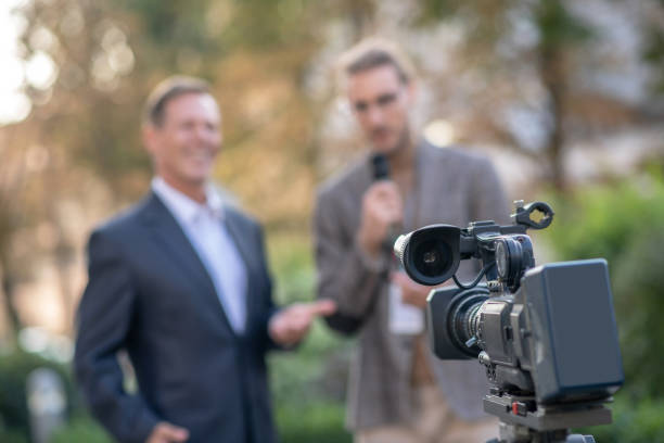 istock Close-up of camera recording interviewing process outside 1280044347