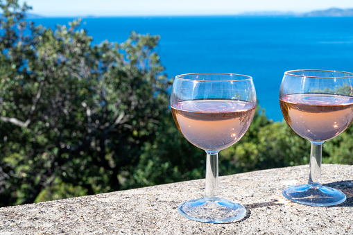 Drinking of local cold rose wine at sunset in summer with sail boats haven of Port grimaud on background, Provence, Var, France