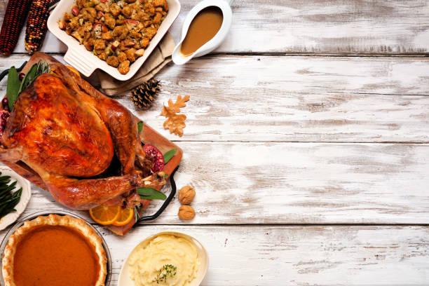 istock Traditional Thanksgiving turkey dinner. Top view side border on a rustic white wood background. 1280046335