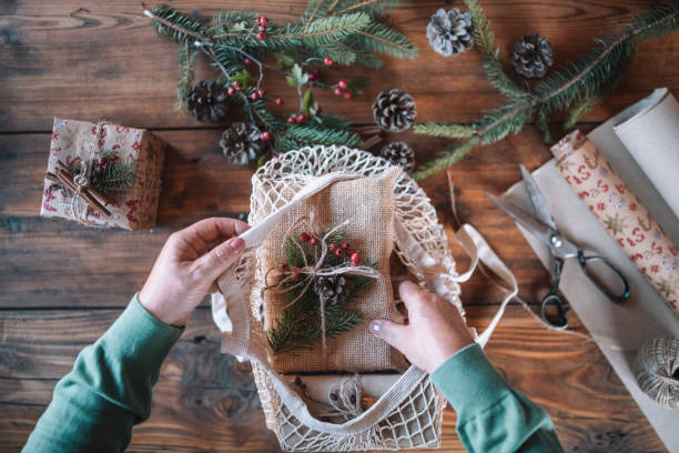 istock Cropped hands arranging wrapped Christmas gift in textile bag. 1280047544