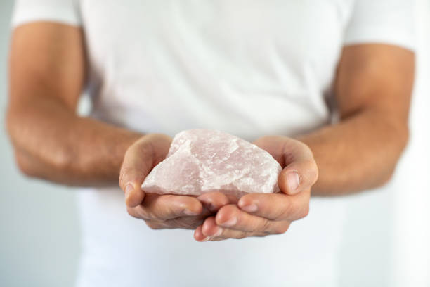 istock Man's hand holds a rose quartz 1280048296