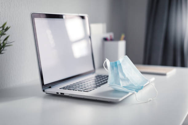 istock Medical protective mask on laptop,  Covid-19 concept, nobody 1280048455