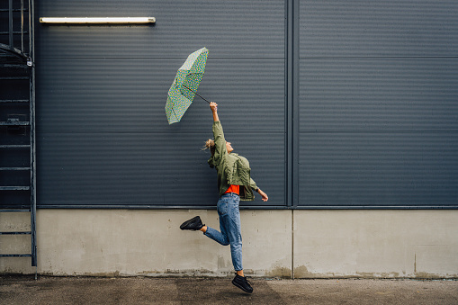 Photo of a young, smiling woman, who is in a good, cheerful mood, despite the bad weather.