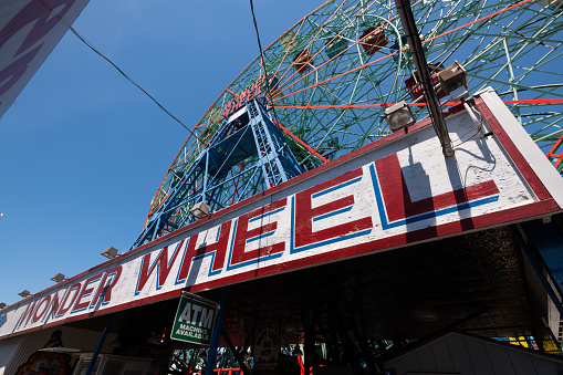 New York City, USA - June 4, 2019: The Wonder Wheel sign on the boardwalk at Coney Island in Brooklyn late in the day.