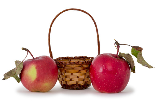 Apples and small basket on a white background.