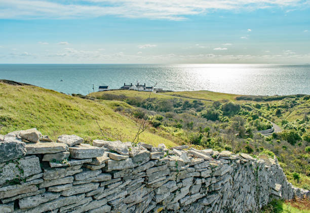 A view down a dry stone wall looking down over Anvil Point Lighthouse near Swanage-Dorset