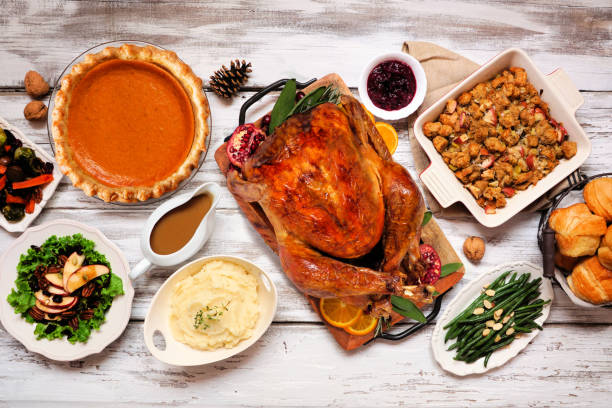 Classic Thanksgiving turkey dinner. Overhead view table scene on a rustic white wood background. Classic Thanksgiving turkey dinner. Overhead view table scene on a rustic white wood background. Turkey, mashed potatoes, stuffing, pumpkin pie and sides. side dish stock pictures, royalty-free photos & images