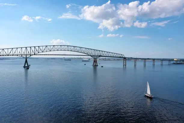 Boats, bridge, sky, and bay seen from an aerial view.