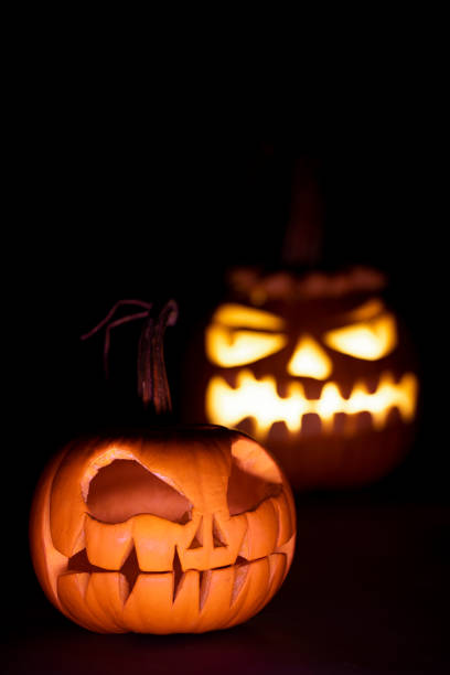 istock two pumkins for halloween, glowing and not glowing 1280055622
