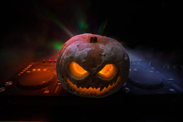istock Halloween pumpkin on a dj table with headphones on dark background with copy space. Happy Halloween festival decorations 1280056448