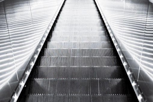 Black and white modern escalator, background with copy space, full frame horizontal composition