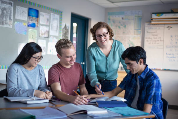 istock Professor explaining to diverse multi-cultural students in classroom 1280058530