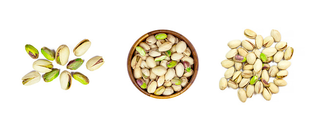 Top view of roasted salted pistachio nuts in nutshell set isolated on white background.