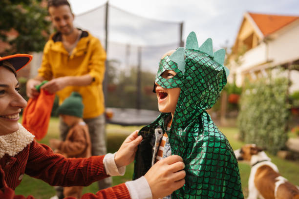 My little dinosaur Photo of a little boy getting ready for the Halloween party with his mom in the backyard of their house. carnival costume stock pictures, royalty-free photos & images