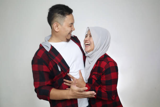 Portrait of happy Asian muslim couple smiling, husband and wife hugging full of love, family concept
