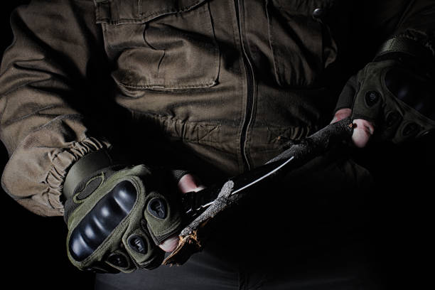 istock Person in brown tactical outfit jacket and gloves using knife. 1280070902