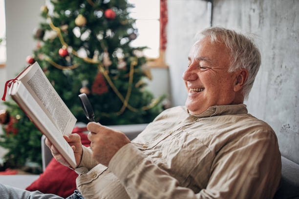 istock One senior man reading a book with the help of a magnifying glass 1280080142