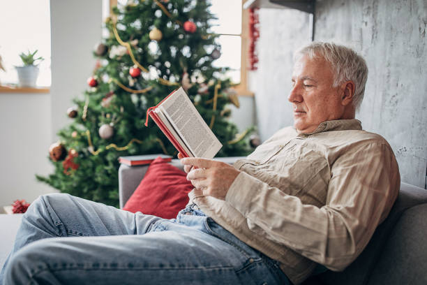 istock Senior man reading a book at home 1280080190