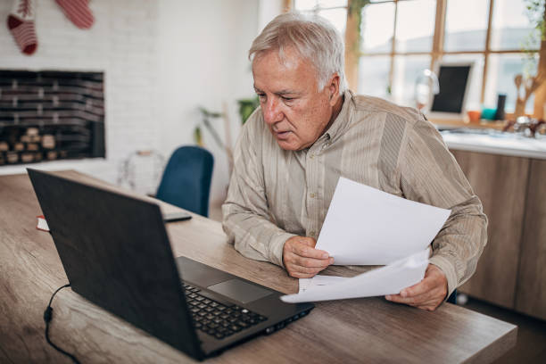 istock Senior businessman going through some paperwork at home 1280081608