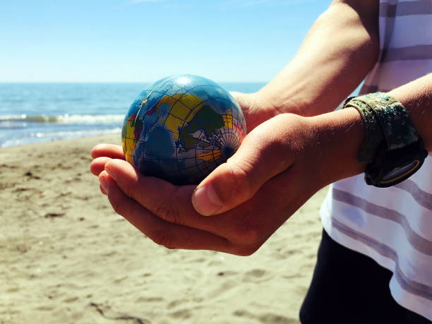 istock Personal Perspective, Child Plays with Globe Ball by Sea 1280082532