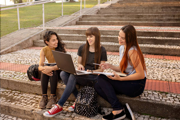 istock Young women studying together using laptop outdoor. 1280086955