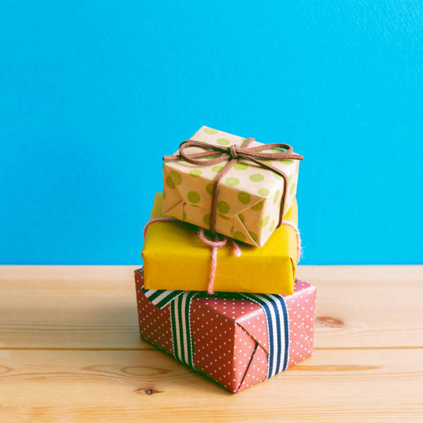 istock Colorful gift boxes on wooden table with blue background 1280091945