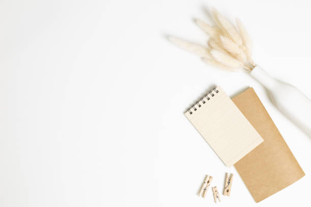istock Notebook with vase of dry grass on white background. flat lay, top view, copy space. Work and study place 1280091962