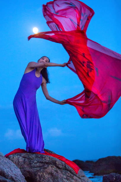 istock Woman dancing in moonlight on a rocky beach in Connecticut. 1280093263