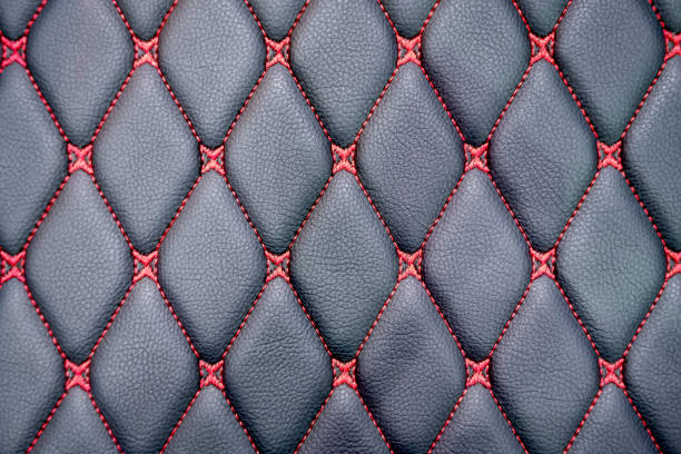 istock Red thread lines in rhombus pattern on surface of black realistic leather car seat 1280094880