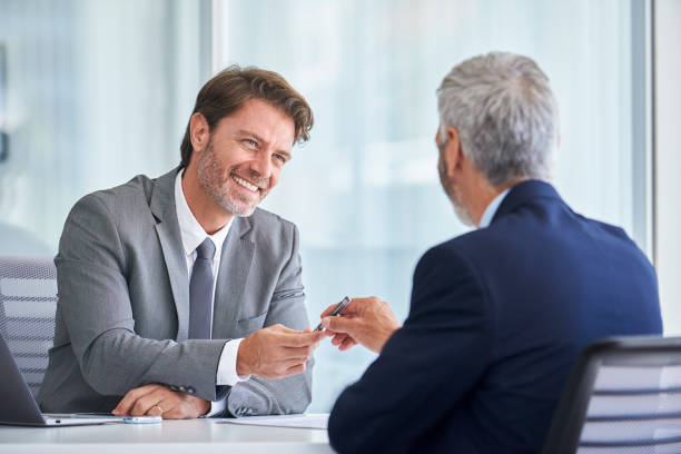 istock Businessman giving pen to his partner 1280097904