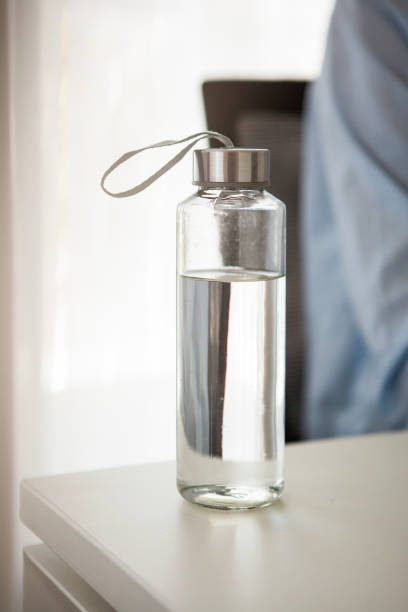 Water Bottle on table Close-up of water bottle on table in office bottled water on table stock pictures, royalty-free photos & images