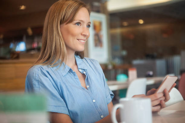 istock Woman using smart phone in coffee store 1280098816