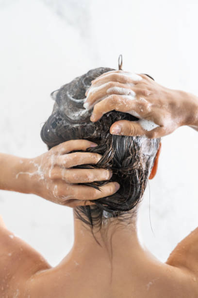 istock Woman applying shampoo on her hair 1280099028
