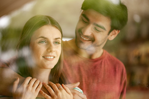 Smiling romantic young couple seen through glass