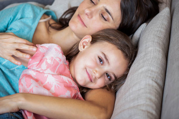 istock Mother and daughter lying on bed 1280099409