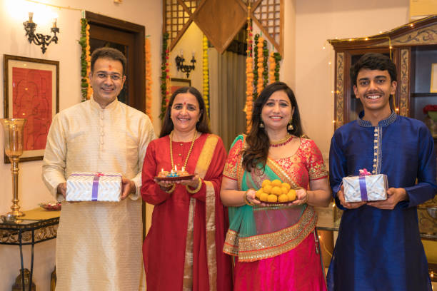 Family in tradional dress holding gift boxes in hand Family in tradional dress holding gift boxes in hand,looking at the camera and smiling diwali photos stock pictures, royalty-free photos & images