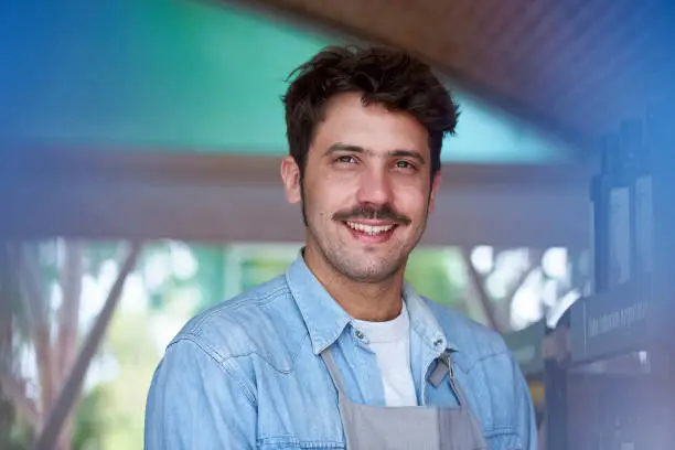 Portrait of man smiling and standing in grocery store