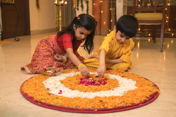 Kids making rangoli decoration at home on festival day