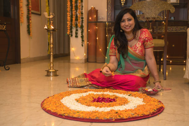 istock Lady in ethnic wear sitting on floor besides rangoli 1280100195