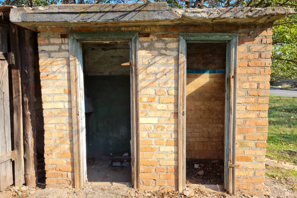 istock abandoned old brick toilet with two doors at sunny summer day. 1280100327
