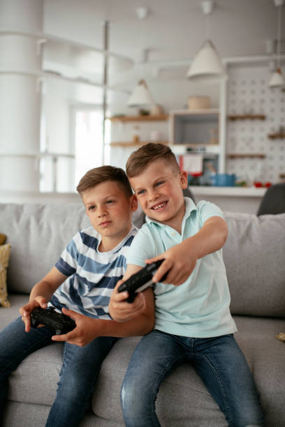 istock Young brothers having fun while playing video games in living room 1280103863