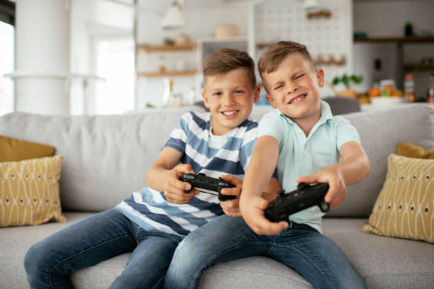 istock Young brothers having fun while playing video games in living room 1280103864