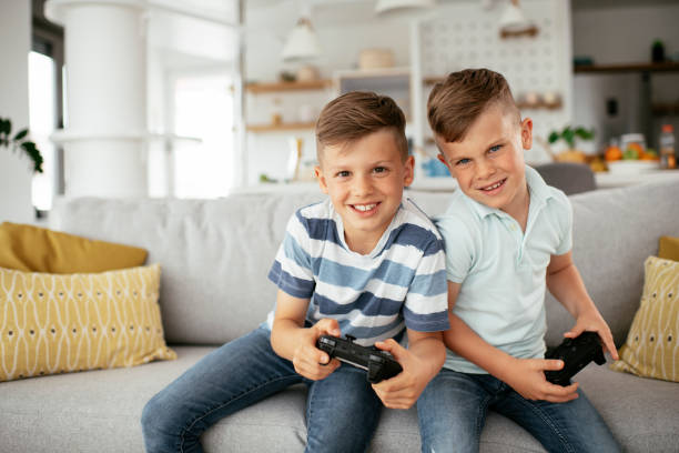 istock Young brothers having fun while playing video games in living room 1280103885