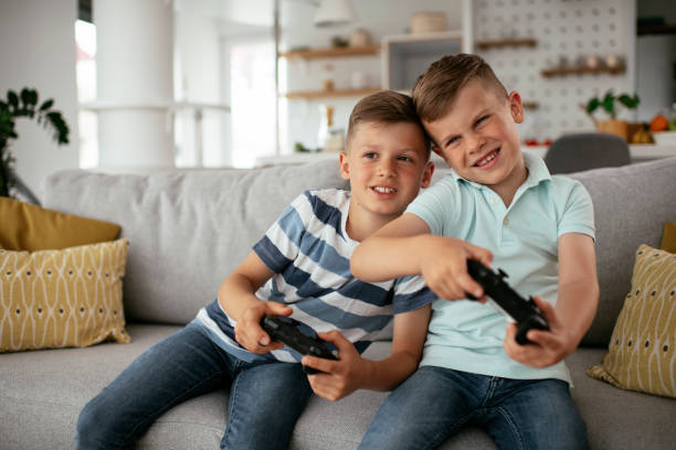 istock Young brothers having fun while playing video games in living room 1280103890