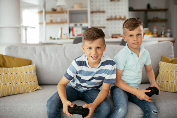 istock Young brothers having fun while playing video games in living room 1280103937