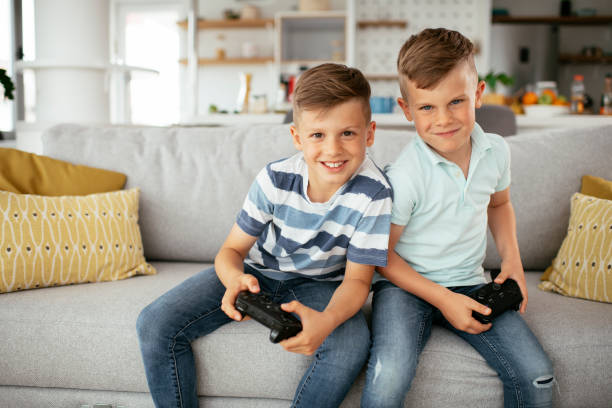 istock Young brothers having fun while playing video games in living room 1280104581