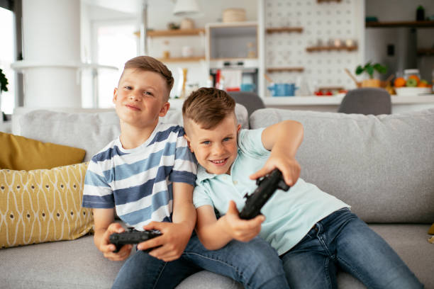 istock Young brothers having fun while playing video games in living room 1280104583