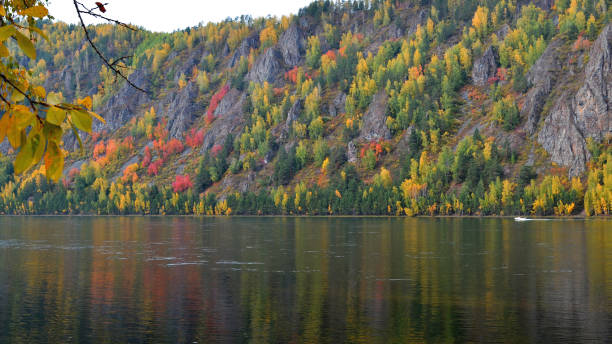 autumn landscape a motor boat floats on the background of mountains with bright yellow red and green colors - 2271 imagens e fotografias de stock