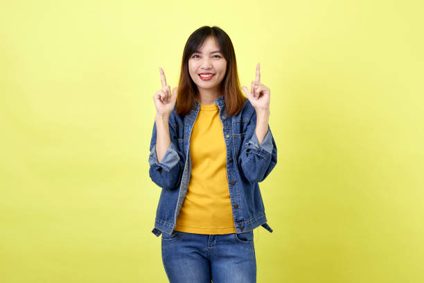 istock Young Asian woman pointing hands on yellow background 1280106789