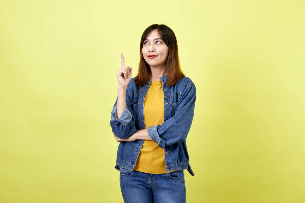 istock Young Asian woman pointing hands on yellow background 1280106796